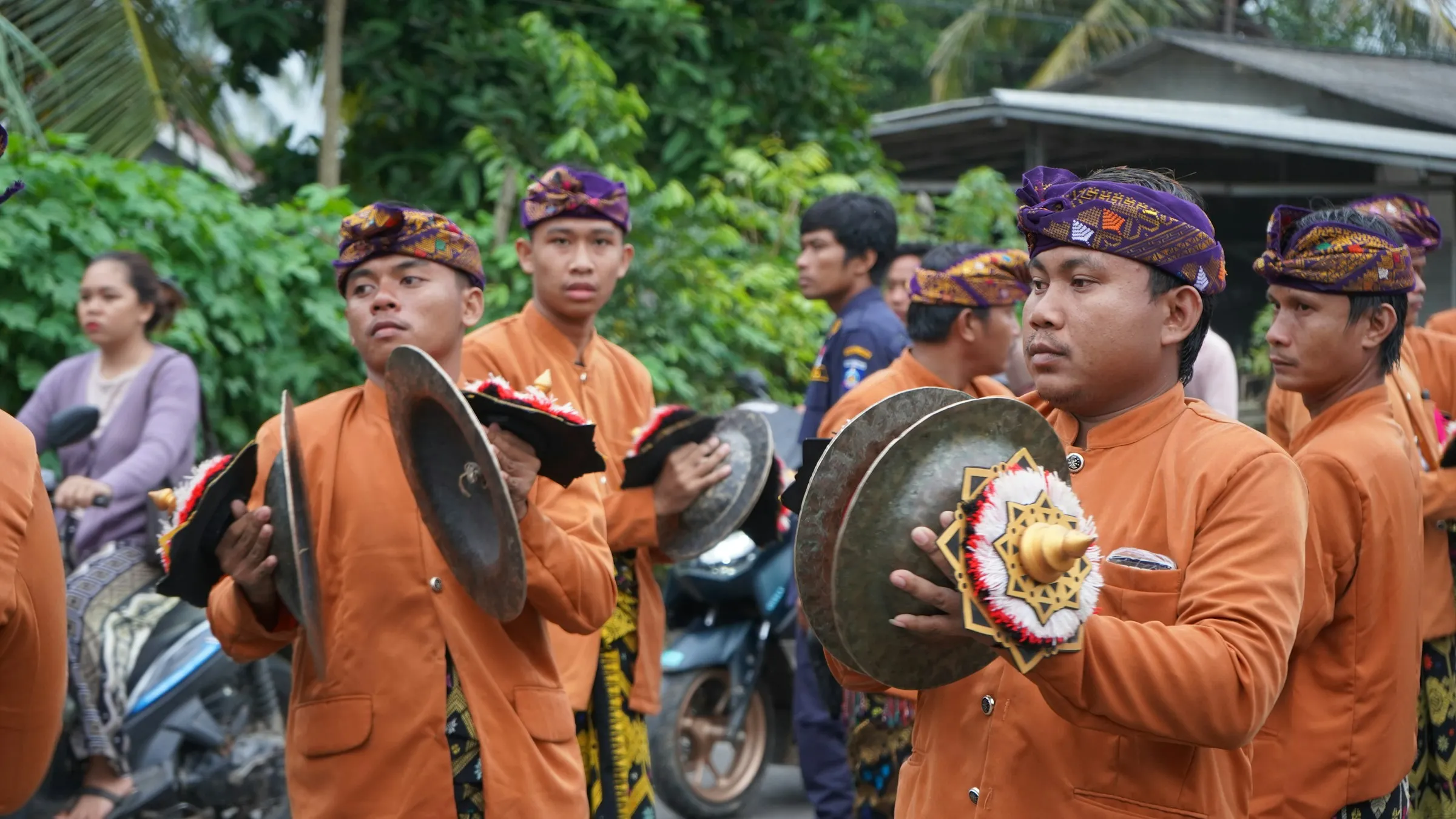 Pemain gong Sasak dalam pakaian seragam memainkan musik pada perayaan pernikahan tradisional, Lombok